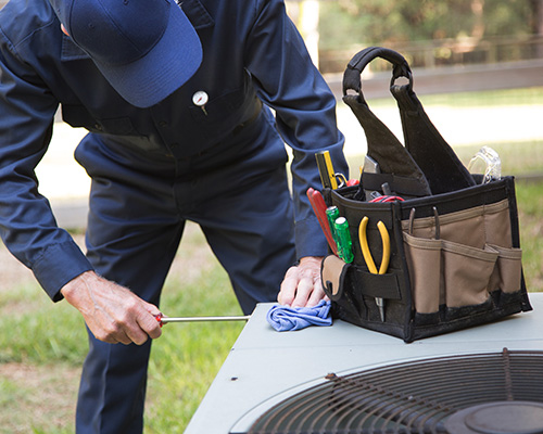 ac-services-hanover-pa HVAC technician repairing AC unit.